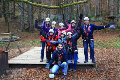 ZHI Friends: Gruppe im Hochseilgarten mit Helmen und Kletterausrüstung. Partnerprogramm ZHIProvide.