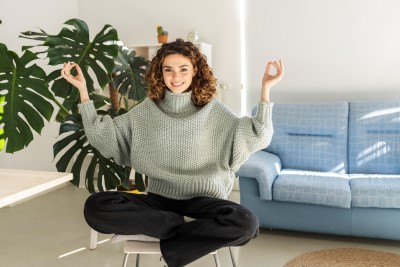Junge Frau mit lockigen Haaren meditiert. Achtsamkeit für ZHI Friends Partnerprogramm.
