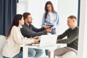 Eine Gruppe von Menschen arbeitet im Büro, indem sie am Tisch sitzt.